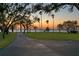 Scenic landscape featuring a paved road, palm trees, lush green grass, and a glimpse of the water at 147 & 139 Edgewater Dr, Dunedin, FL 34698