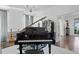Sophisticated living room featuring a grand piano, chandelier, and hardwood floors, creating an inviting space at 147 & 139 Edgewater Dr, Dunedin, FL 34698