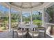 Enclosed patio with round table, seating, and garden view provides a relaxing outdoor dining space at 147 & 139 Edgewater Dr, Dunedin, FL 34698