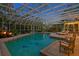 Enclosed pool area featuring tropical plants, waterfall feature, dolphin tile, lounge chairs, and an adjacent dining area at 147 & 139 Edgewater Dr, Dunedin, FL 34698