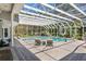 Enclosed pool area with waterfall feature, lush landscaping, and chaise lounges for relaxing at 147 & 139 Edgewater Dr, Dunedin, FL 34698