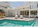 Enclosed pool with lounge chairs, garden views, and a gazebo offers a private backyard escape at 147 & 139 Edgewater Dr, Dunedin, FL 34698
