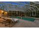 Enclosed pool area featuring lounge chairs, tropical plants, waterfall feature, and an adjacent building at 147 & 139 Edgewater Dr, Dunedin, FL 34698