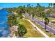Scenic coastal road lined with palm trees, a walking path, and views of the water at 147 & 139 Edgewater Dr, Dunedin, FL 34698