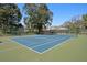 Well-maintained tennis court with a blue playing surface and green surround at 147 & 139 Edgewater Dr, Dunedin, FL 34698