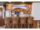 This custom wet bar features wood cabinets, a microwave, a wine cooler, and seating for a relaxing entertainment space at 147 & 139 Edgewater Dr, Dunedin, FL 34698