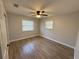 Bright bedroom featuring modern ceiling fan, wood-look flooring, and natural light from the windows at 1504 Swilley Rd, Plant City, FL 33567