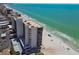 Magnificent aerial view of beachfront condos on a white sand beach with clear turquoise water and blue skies at 15462 Gulf Blvd # 504, Madeira Beach, FL 33708