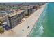 Gorgeous aerial view of beachfront condos on a white sand beach with clear turquoise water and blue skies at 15462 Gulf Blvd # 504, Madeira Beach, FL 33708