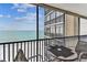 Balcony with a table and chairs overlooking the beach and other buildings at 15462 Gulf Blvd # 504, Madeira Beach, FL 33708
