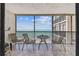 A spacious balcony with comfortable seating overlooks the beach and ocean beyond the railing at 15462 Gulf Blvd # 504, Madeira Beach, FL 33708