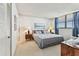 A charming bedroom featuring a window with bright blue curtains, and soft natural light at 15462 Gulf Blvd # 504, Madeira Beach, FL 33708