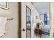 A hallway with access to the bedroom featuring a window with blue curtains and a wooden side table at 15462 Gulf Blvd # 504, Madeira Beach, FL 33708