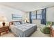 Bright bedroom with a window and blue curtains, a cozy chair, and comfy quilt at 15462 Gulf Blvd # 504, Madeira Beach, FL 33708