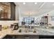 Modern kitchen featuring granite counters and stainless steel sink overlooking the living area at 15462 Gulf Blvd # 504, Madeira Beach, FL 33708