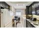 Galley kitchen featuring stainless appliances and custom cabinetry with adjacent laundry and desk area at 15462 Gulf Blvd # 504, Madeira Beach, FL 33708