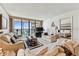 Comfortable living room boasts a waterfront view, plush seating, and bright interior with beige decor at 15462 Gulf Blvd # 504, Madeira Beach, FL 33708