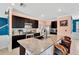 Modern kitchen features stainless steel appliances, black cabinetry, and a spacious granite countertop island at 16149 Tuscany Hillside Rd, Odessa, FL 33556
