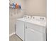 Laundry room area with washing machine, dryer, and shelving for cleaning supplies at 16149 Tuscany Hillside Rd, Odessa, FL 33556