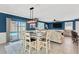 Bright dining and living space with sliding doors to backyard pool, an island table and TV at 16149 Tuscany Hillside Rd, Odessa, FL 33556
