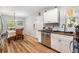 Bright dining area featuring hardwood floors and white cabinets and stainless steel dishwasher at 186 Grand Ave, Brooksville, FL 34604