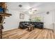 Cozy living room featuring hardwood floors, a ceiling fan, and a comfortable black leather sofa at 186 Grand Ave, Brooksville, FL 34604