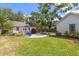 Manicured backyard with a rounded patio seating area and garage at 1905 Mckinley St, Clearwater, FL 33765