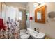 A view of the bathroom with a shower, toilet, and sink with floral curtains at 1905 Mckinley St, Clearwater, FL 33765