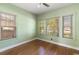 A view of the bedroom with three windows letting in natural light and wood flooring at 1905 Mckinley St, Clearwater, FL 33765