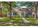 Charming home featuring a well-manicured lawn, beautiful trees, and classic architecture with eye-catching blue shutters at 1905 Mckinley St, Clearwater, FL 33765
