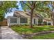 Charming home featuring a well-manicured lawn, beautiful trees, and classic architecture with eye-catching blue shutters at 1905 Mckinley St, Clearwater, FL 33765