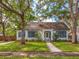 Charming home featuring a well-manicured lawn, beautiful trees, and classic architecture with eye-catching blue shutters at 1905 Mckinley St, Clearwater, FL 33765