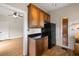 A view of the kitchen with a black fridge and wooden cabinets with a black countertop at 1905 Mckinley St, Clearwater, FL 33765