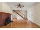 Inviting living room featuring hardwood floors, a cozy brick fireplace, and a staircase, exuding warmth and character at 1905 Mckinley St, Clearwater, FL 33765