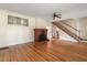 Inviting living room featuring hardwood floors, a cozy brick fireplace, and a staircase, exuding warmth and character at 1905 Mckinley St, Clearwater, FL 33765