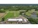 Aerial shot showcases community, golf course, clubhouse, parking, ponds, and lush greenery at 2113 Golf Manor Blvd, Valrico, FL 33596