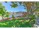 A tranquil backyard featuring a privacy fence, lush green grass, mature trees, and a screened-in pool at 2113 Golf Manor Blvd, Valrico, FL 33596