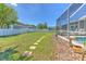 An expansive backyard with a well-maintained lawn, stepping stones, and a screened-in pool at 2113 Golf Manor Blvd, Valrico, FL 33596