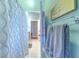 Well-lit bathroom featuring a decorative shower curtain, light-green walls, and well-lit corridor at 2113 Golf Manor Blvd, Valrico, FL 33596