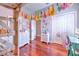 Cozy bedroom featuring a loft bed, colorful decorations, hardwood floors, and bright natural light at 2113 Golf Manor Blvd, Valrico, FL 33596