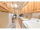 Well-equipped laundry room with abundant storage, tile flooring, and modern washer/dryer unit at 2113 Golf Manor Blvd, Valrico, FL 33596