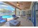 Covered patio featuring comfortable seating, ceiling fans, TV, and a view of the backyard pool at 2113 Golf Manor Blvd, Valrico, FL 33596