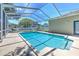 A refreshing, screened-in pool with a sun-drenched deck is ready for a swim on a clear sunny day at 2113 Golf Manor Blvd, Valrico, FL 33596