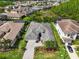 Aerial view of a spacious home with well-manicured landscaping, paver driveway, and lush greenery in a suburban setting at 2165 Hollow Forest Ct, Wesley Chapel, FL 33543