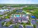 Stunning aerial view of community amenities including a pool, tennis courts, a clubhouse, and lush landscaping at 2165 Hollow Forest Ct, Wesley Chapel, FL 33543
