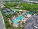 Birds eye view of community pool area with tennis courts and clubhouse, offering a resort-style living experience at 2165 Hollow Forest Ct, Wesley Chapel, FL 33543