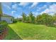Expansive backyard featuring lush green grass, mature trees, and a well-maintained fence, ideal for outdoor activities at 2165 Hollow Forest Ct, Wesley Chapel, FL 33543
