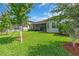 Beautiful backyard showcasing a well-maintained lawn, mature trees, and views of the home's exterior at 2165 Hollow Forest Ct, Wesley Chapel, FL 33543