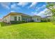 Manicured backyard with lush grass, trimmed hedges and a screened porch provides a relaxing and private outdoor space at 2165 Hollow Forest Ct, Wesley Chapel, FL 33543