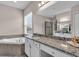 Bathroom featuring a large soaking tub and granite-topped vanity at 2165 Hollow Forest Ct, Wesley Chapel, FL 33543